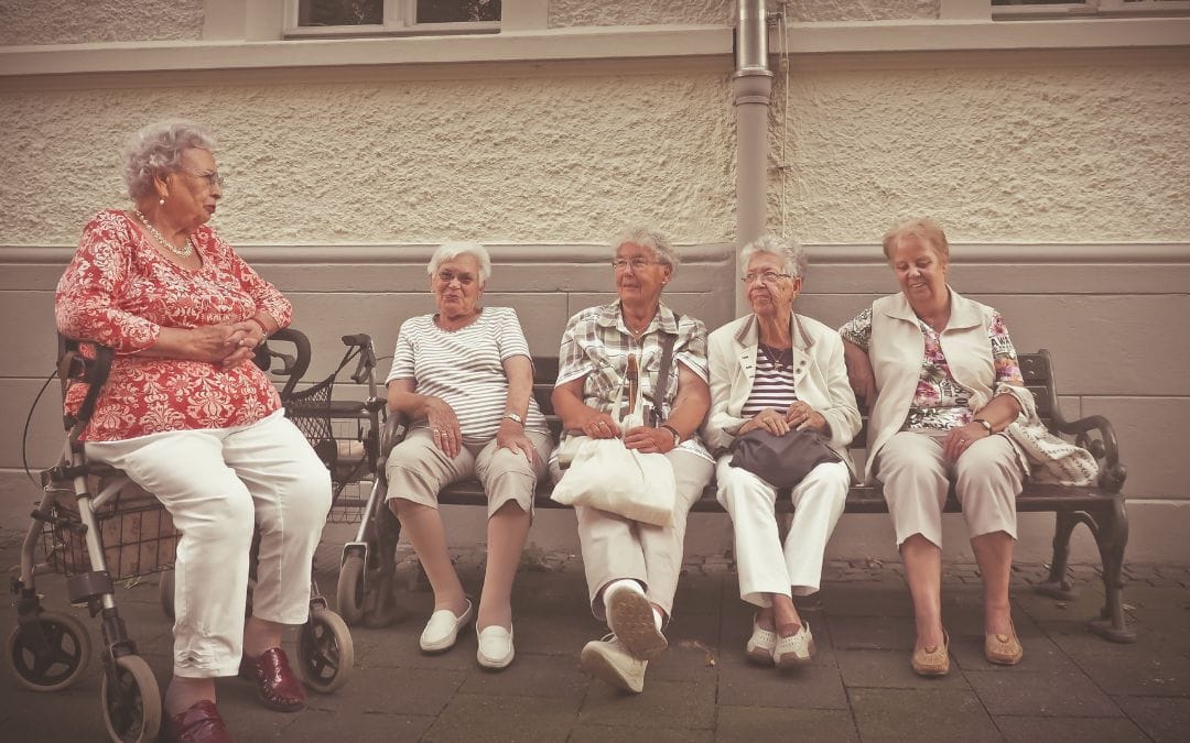 Senior women sitting on bench chatting
