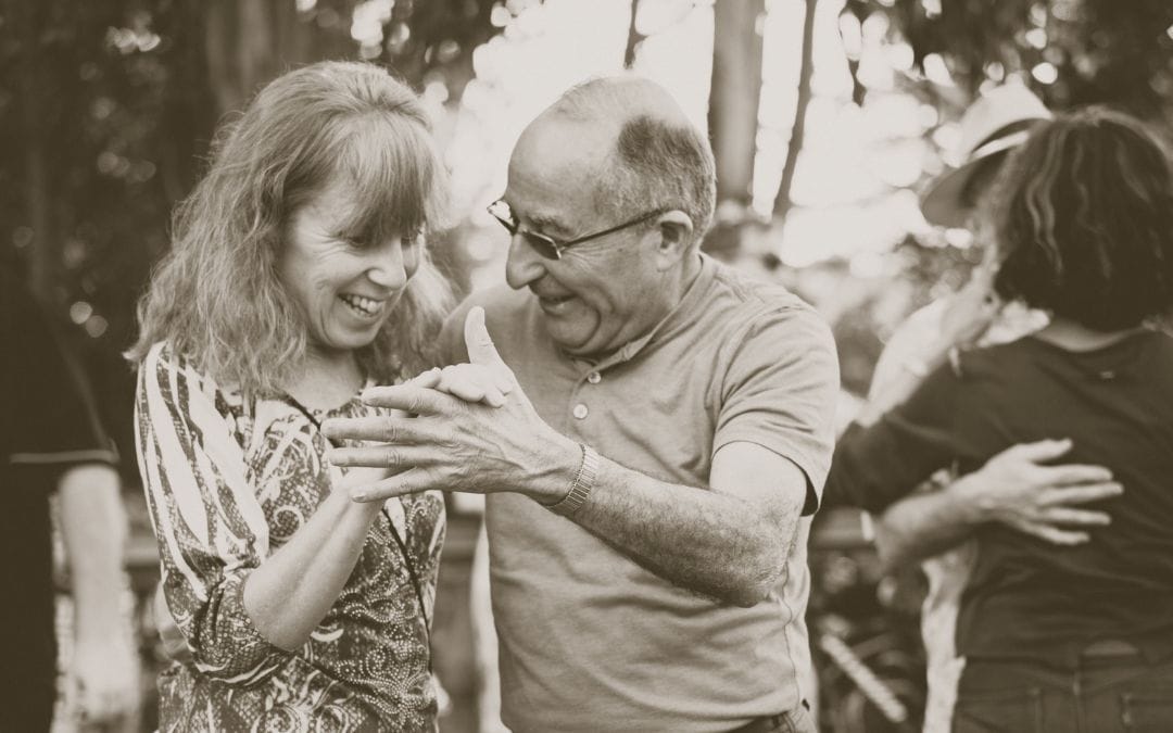 Older couple dancing outside