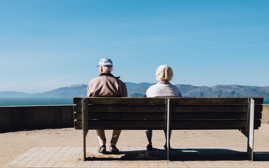 Senior couple sitting on park bench together