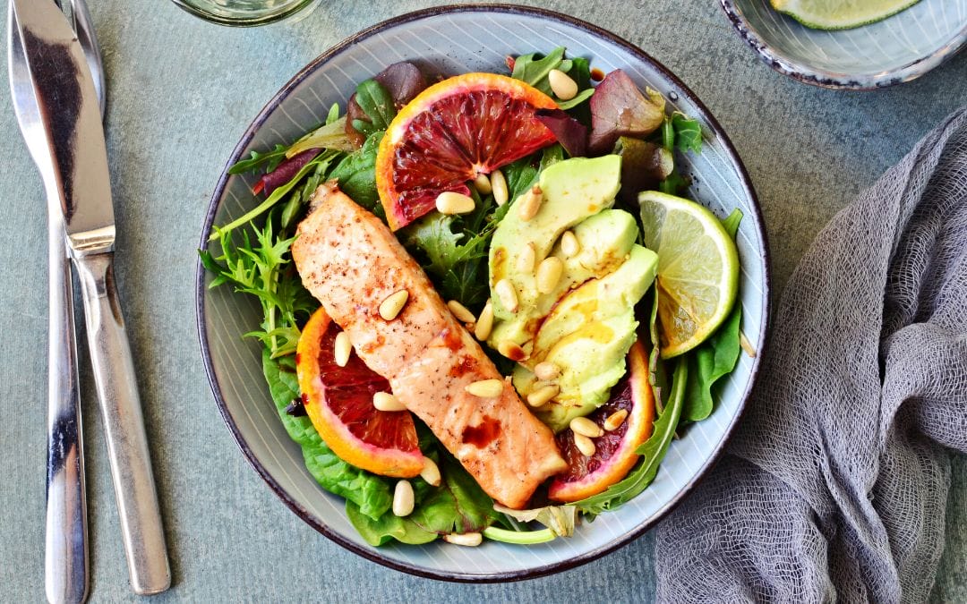 Plate of salmon, salad, avocado, and blood orange
