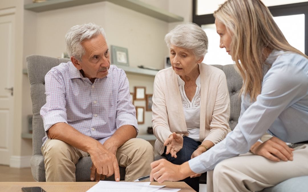 Senior couple discussing paperwork with woman