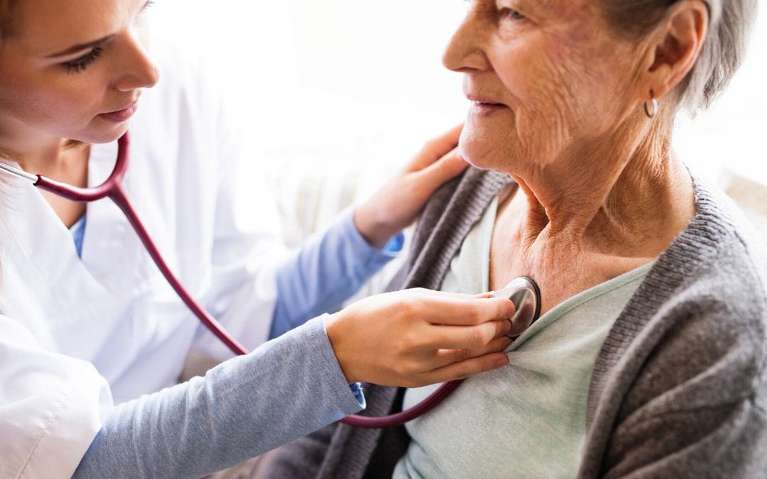 Elderly women getting heart checked by doctor with stethoscope