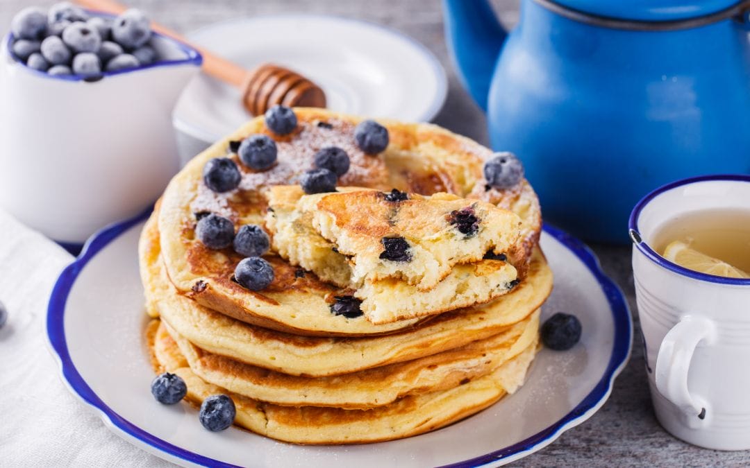 Stack of blueberry pancakes with tea