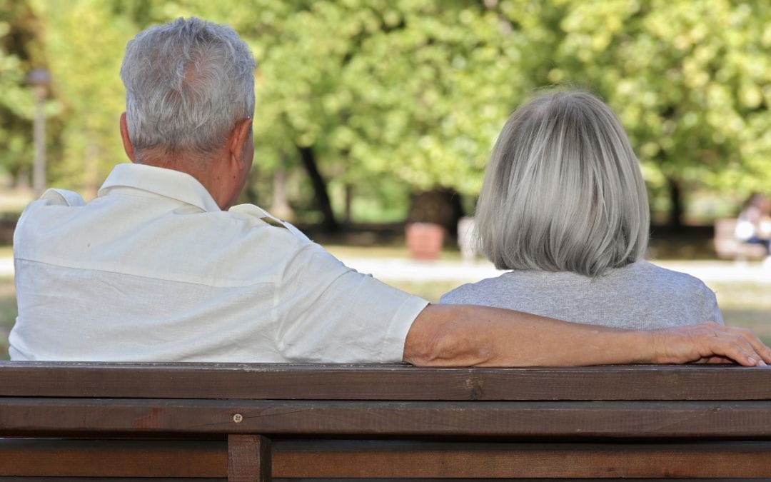 Senior couple sitting on park bench