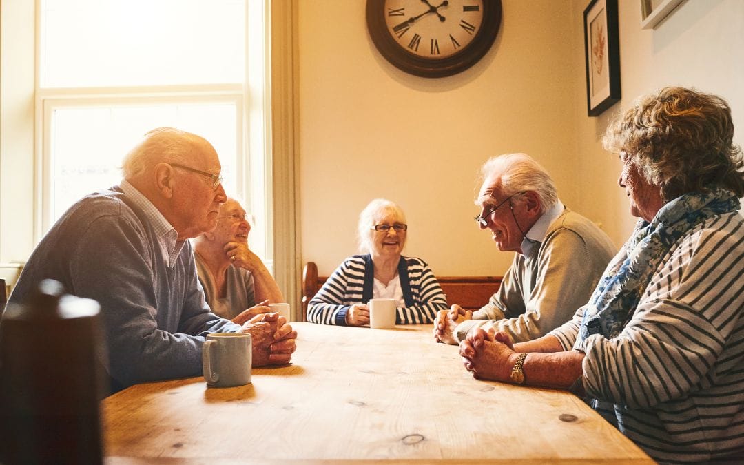 Seniors chatting at dinner table having coffee