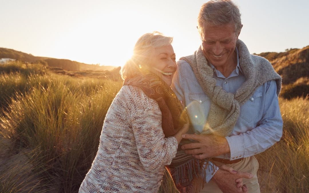 Senior couple laughing outside in field